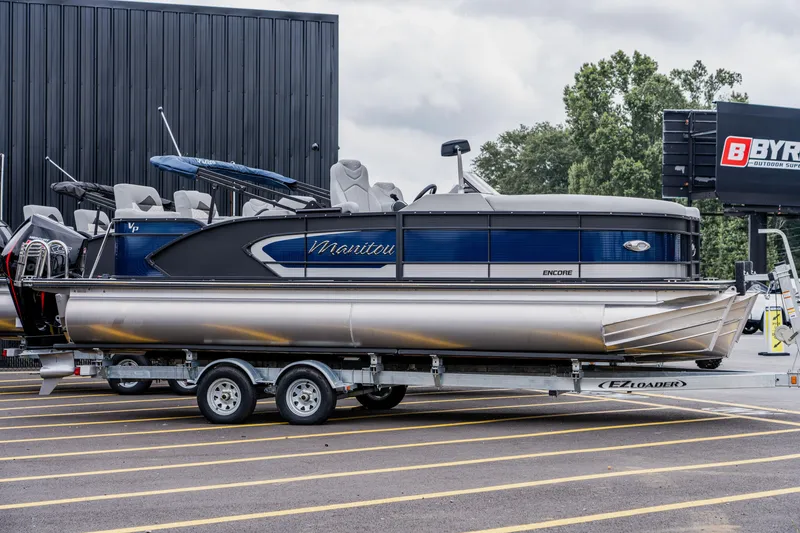 Slide: The Image of 2022 Manitou 23 Encore pontoon boat on a trailer in a parking lot. - 4