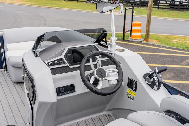 Slide: The Image of 2022 Manitou 23 Encore boat dashboard with steering wheel and controls. - 6