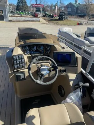 Slide: The Image of 2023 Starcraft CX 25 RL Tritoon dashboard with steering wheel and controls. - 7