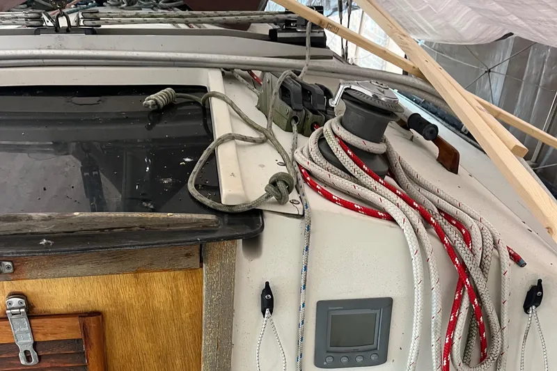 Slide: The Image of 1980 C&C 34 sailboat deck with ropes, winch, and wooden hatch. - 10