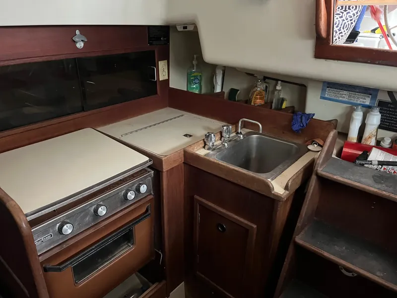 Slide: The Image of 1980 C&C 34 yacht kitchen with stove, sink, and storage. - 5