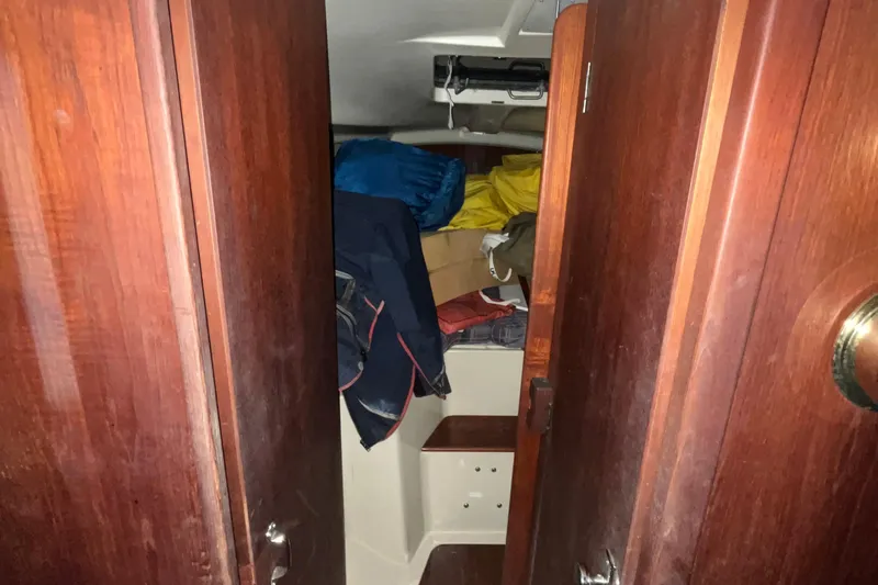 Slide: The Image of Interior cabin of 1980 C&C 34 sailboat with wooden doors and stored gear. - 7