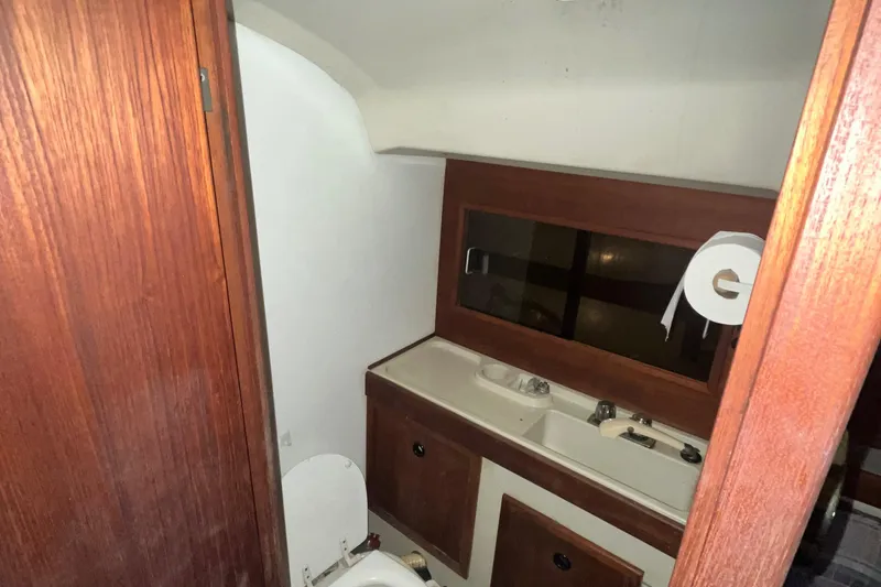 Slide: The Image of 1980 C&C 34 yacht bathroom with wooden cabinets and a mirror. - 8