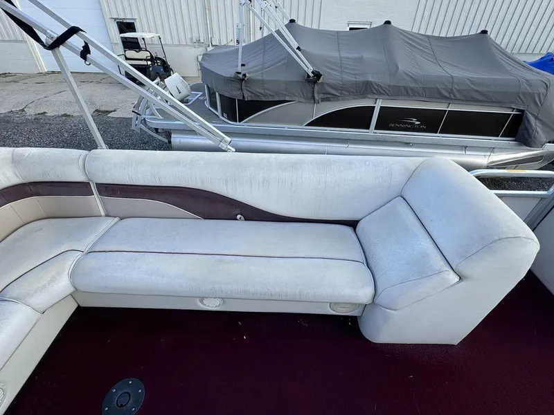 Slide: The Image of 2001 Godfrey Sweetwater boat interior with white seating and maroon carpet. - 5