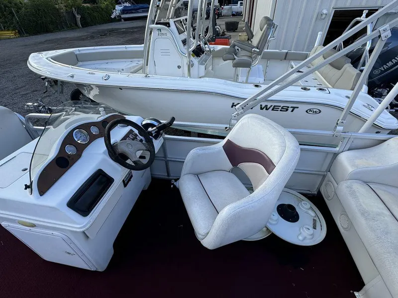 Slide: The Image of 2001 Godfrey Sweetwater boat interior with steering wheel and seating. - 7