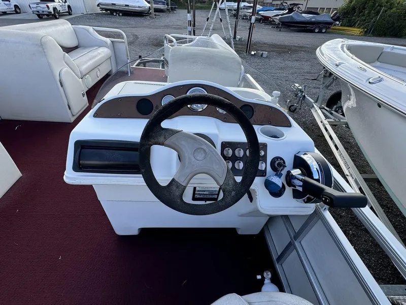 Slide: The Image of 2001 Godfrey Sweetwater boat steering console with controls and seating. - 8