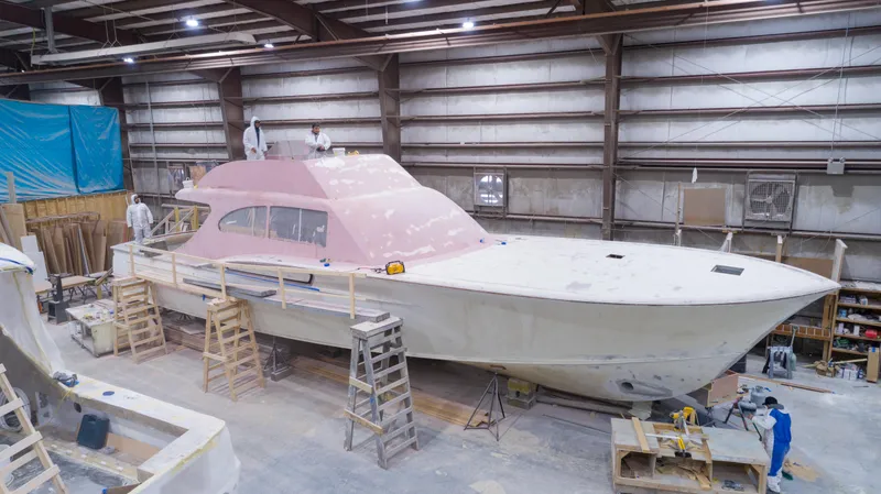 Slide: The Image of 2024 Custom Carolina 63 yacht under construction in a workshop, showcasing skilled craftsmanship. - 1