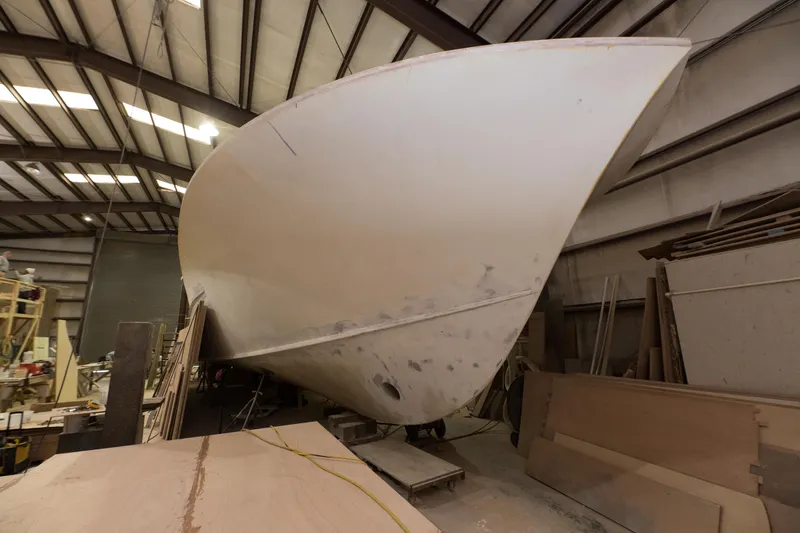 Slide: The Image of 2024 Custom Carolina 63 boat under construction in a workshop. - 11