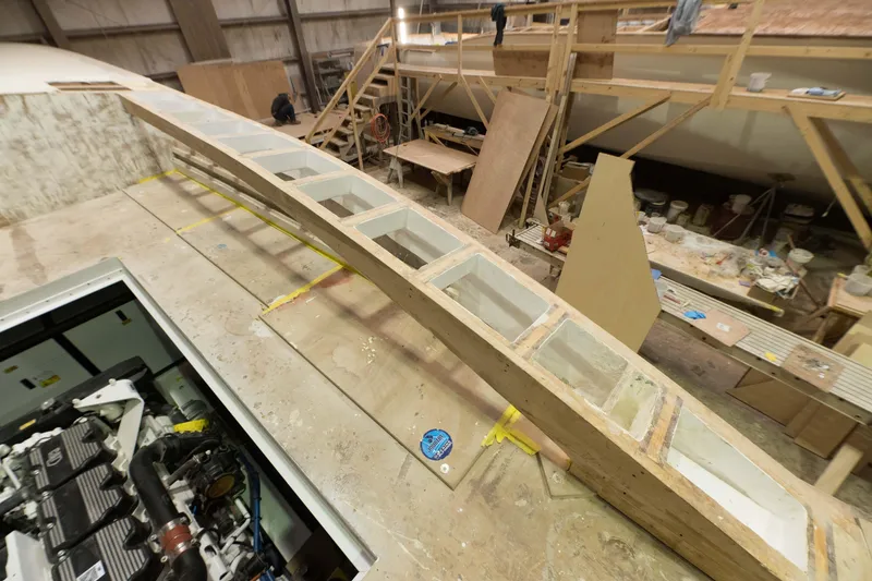 Slide: The Image of Custom Carolina 63 boat under construction in a workshop, 2024 model. - 34