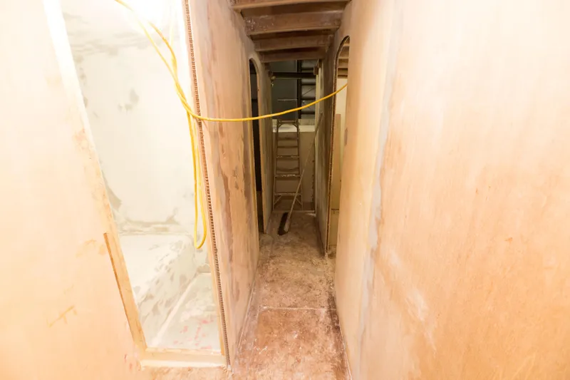 Slide: The Image of 2024 Custom Carolina 63 interior under construction, showing narrow hallway and unfinished walls. - 47