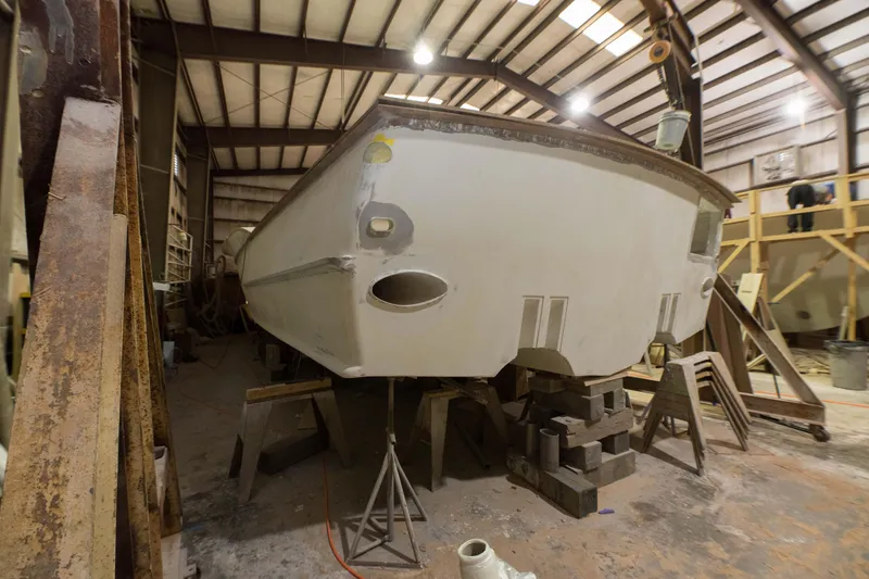 Slide: The Image of Custom Carolina 63 boat under construction in a workshop, 2024 model. - 6