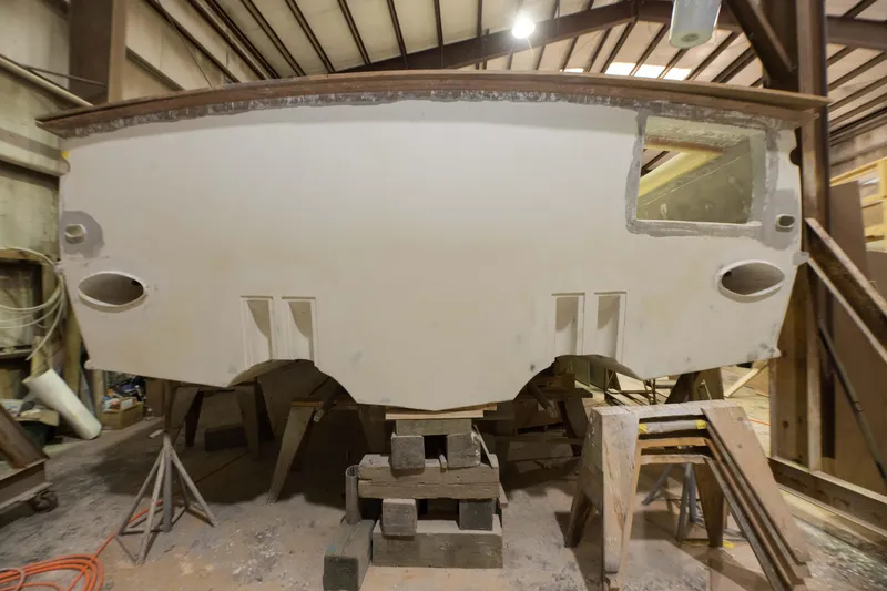 Slide: The Image of Custom Carolina 63 boat under construction in a workshop, 2024 model. - 8