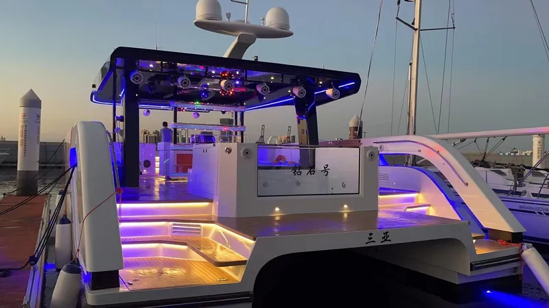 Slide: The Image of 2024 Diamond Yachts P55 Power Catamaran with illuminated deck at sunset. - 8