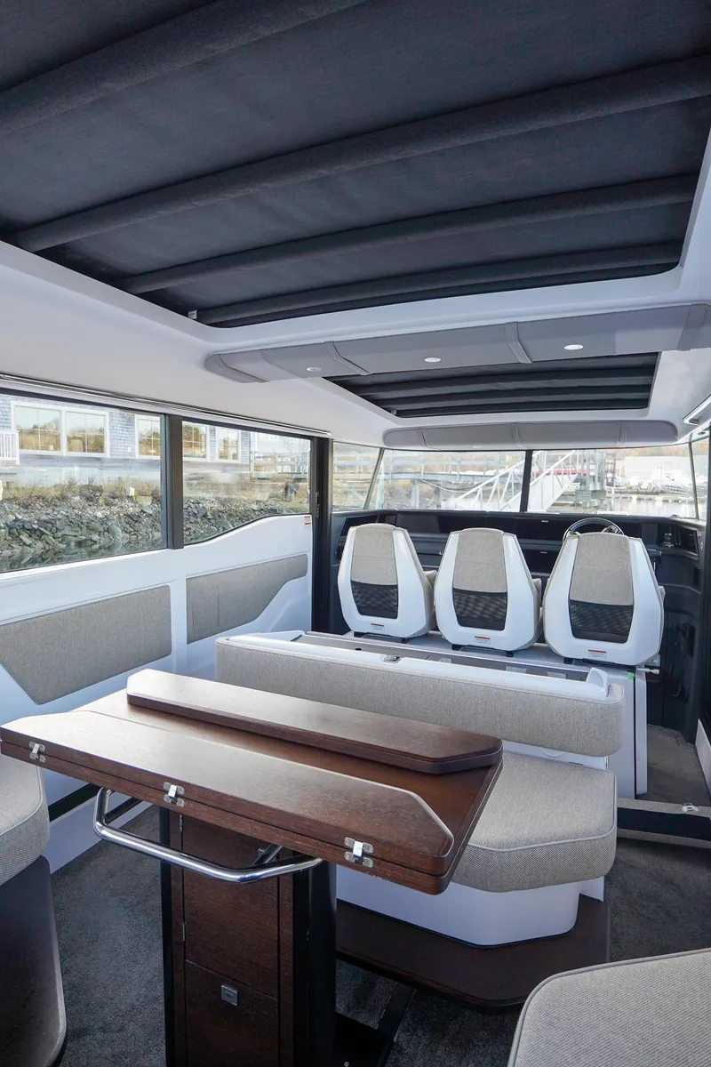 Slide: The Image of Interior of 2024 Axopar 45 boat with modern seating and table. - 11