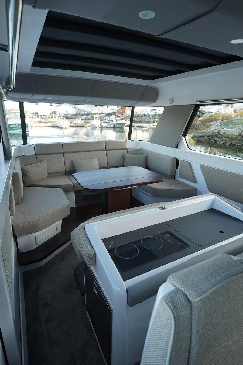 Slide: The Image of 2024 Axopar 45 interior with modern seating and dining area. - 12