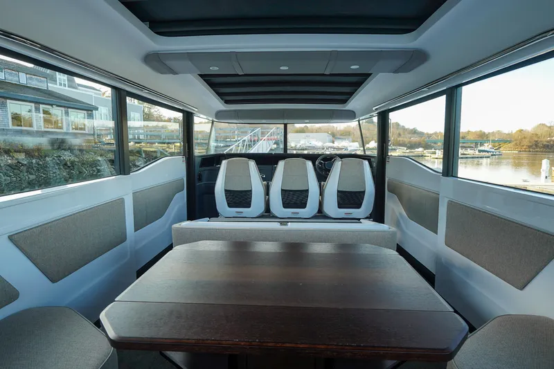 Slide: The Image of 2024 Axopar 45 interior with seating and table, panoramic windows, and modern design. - 7