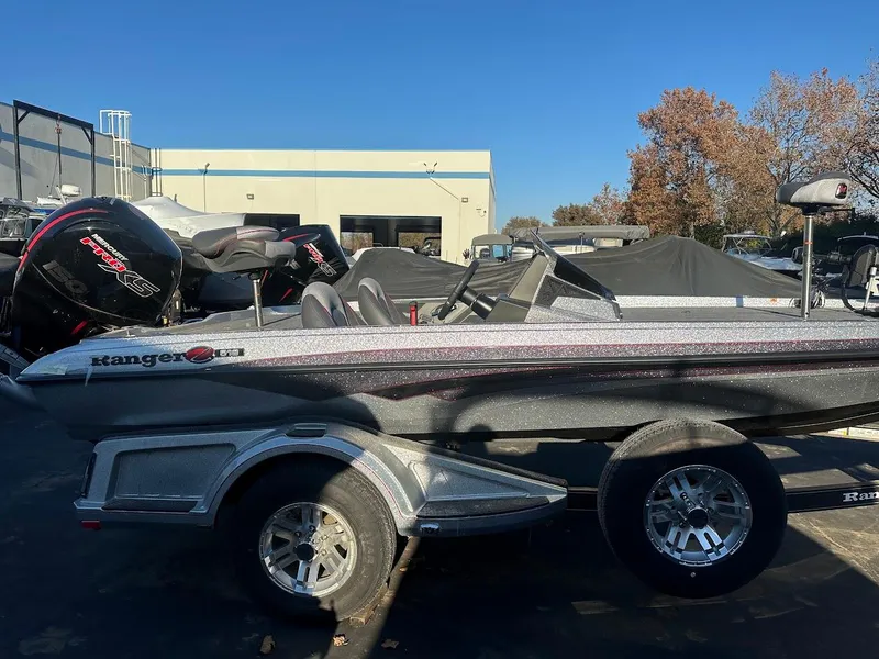 Slide: The Image of 2024 Ranger Z518 boat on trailer, parked outdoors, with clear blue sky. - 1