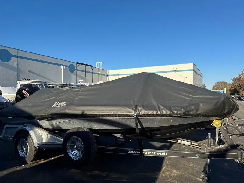 Slide: The Image of 2024 Ranger Z518 boat covered on trailer, parked outdoors. - 10