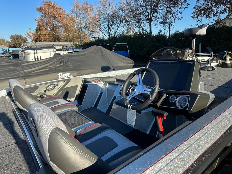 Slide: The Image of 2024 Ranger Z518 boat interior with steering wheel and dashboard, parked outdoors. - 5