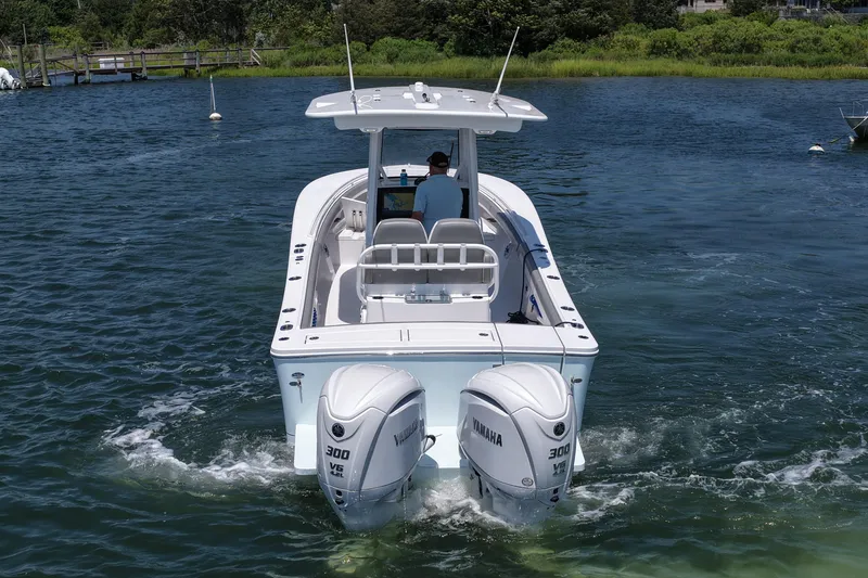 Slide: The Image of 2025 Regulator 28 boat with dual Yamaha 300 engines cruising on a serene waterway. - 10