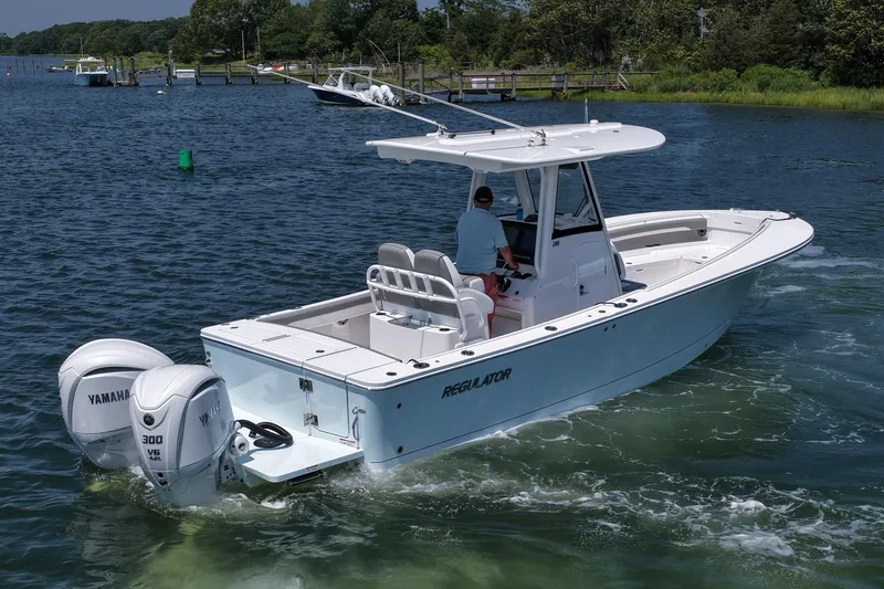 Slide: The Image of 2025 Regulator 28 boat with twin Yamaha engines cruising on a scenic waterway. - 12
