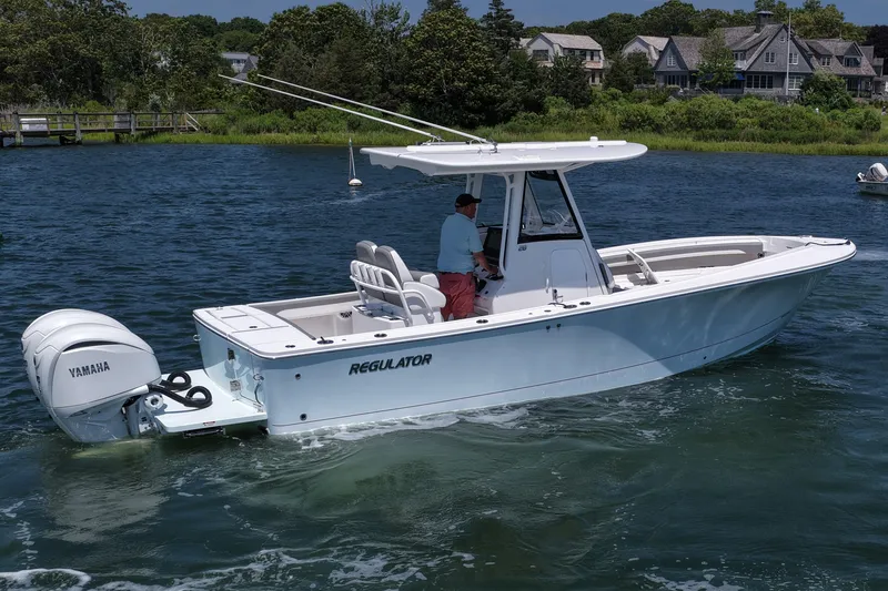 Slide: The Image of 2025 Regulator 28 boat with Yamaha engine cruising on a scenic waterway. - 13