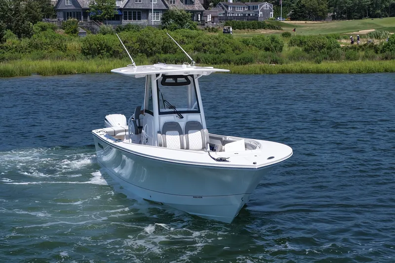 Slide: The Image of 2025 Regulator 28 boat cruising on a scenic lake near waterfront homes. - 2