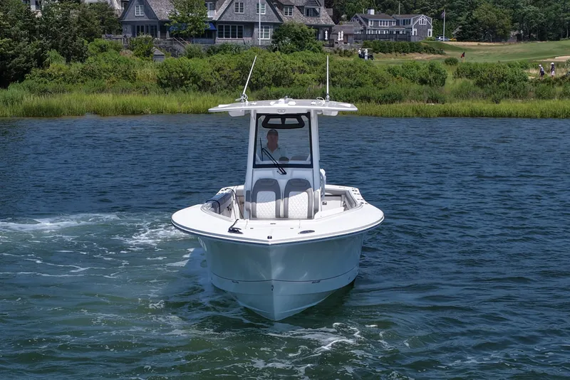 Slide: The Image of 2025 Regulator 28 boat cruising on a scenic lake near waterfront homes. - 3