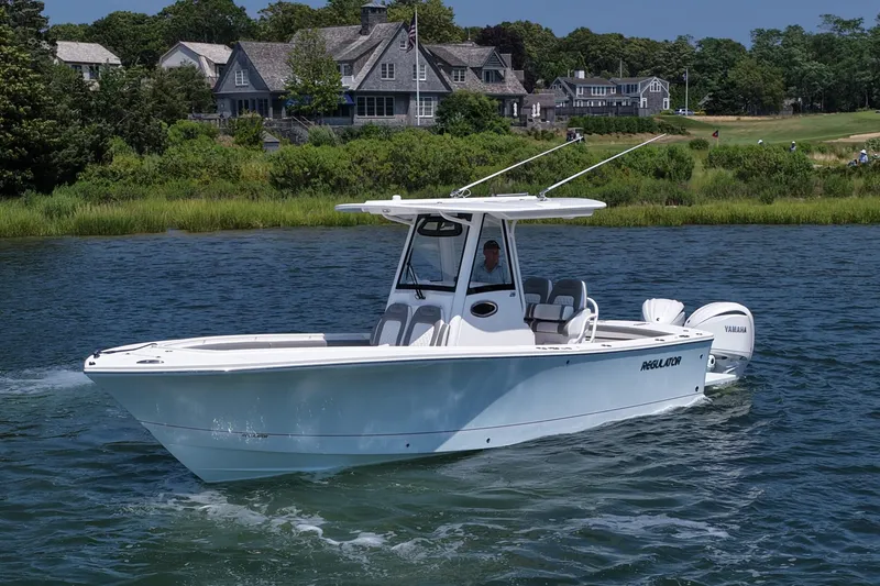 Slide: The Image of 2025 Regulator 28 boat cruising on a scenic lake near waterfront homes. - 5