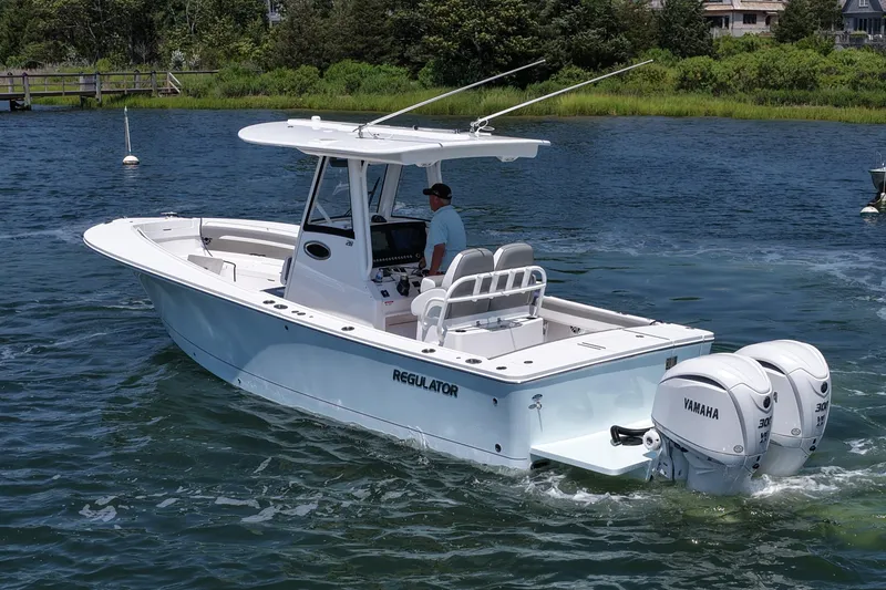 Slide: The Image of 2025 Regulator 28 boat with twin Yamaha engines cruising on a scenic waterway. - 8
