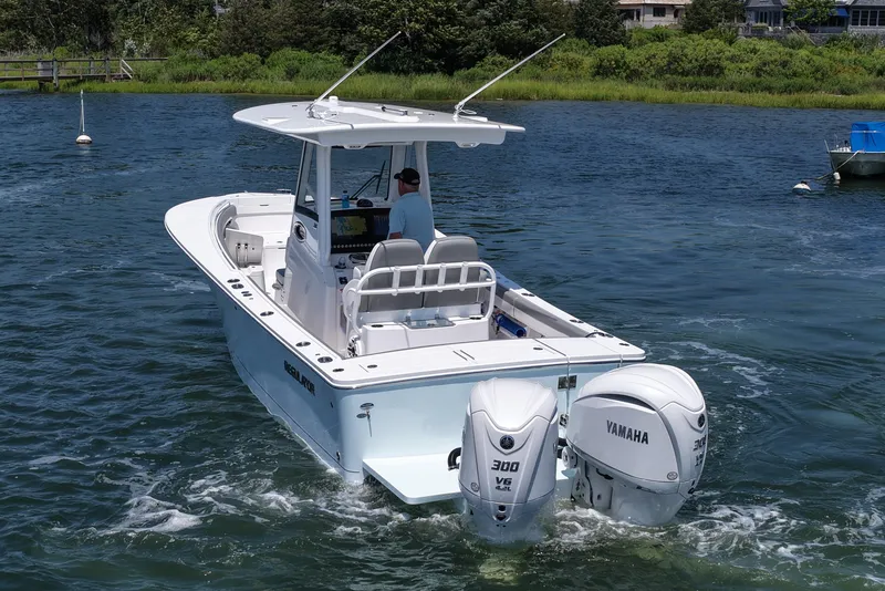 Slide: The Image of 2025 Regulator 28 boat with twin Yamaha 300 engines on a calm waterway. - 9