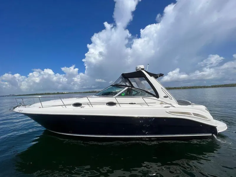 Slide: The Image of 2002 Sea Ray 340 Sundancer boat on calm water under a blue sky. - 0