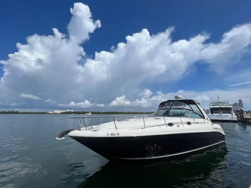 Slide: The Image of 2002 Sea Ray 340 Sundancer yacht docked on a sunny day with cloudy sky. - 1