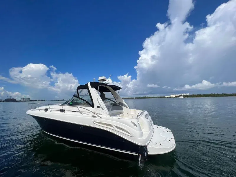 Slide: The Image of 2002 Sea Ray 340 Sundancer boat on calm water under a clear blue sky. - 2