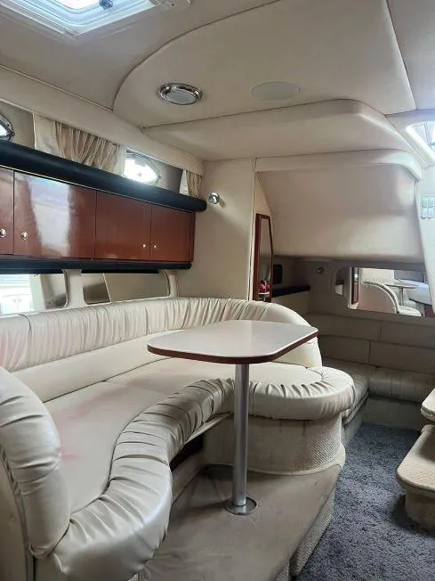 Slide: The Image of Interior of 2002 Sea Ray 340 Sundancer with beige seating and wooden cabinets. - 8