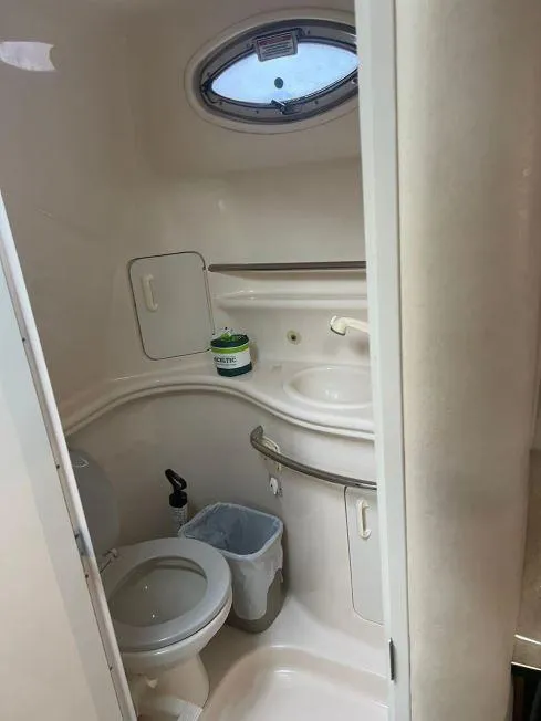 Slide: The Image of Compact bathroom in 2002 Sea Ray 340 Sundancer boat with toilet, sink, and porthole. - 9