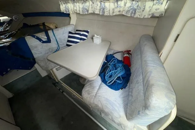 Slide: The Image of 1993 Carver 280 Express cabin interior with dinette, seating, and nautical decor. - 26