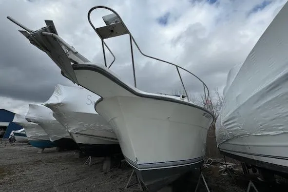 Slide: The Image of 1993 Carver 280 Express boat in storage yard, surrounded by other covered boats. - 8