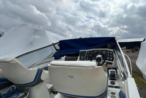 Slide: The Image of 1993 Carver 280 Express boat cockpit with covered dashboard and white seats. - 9