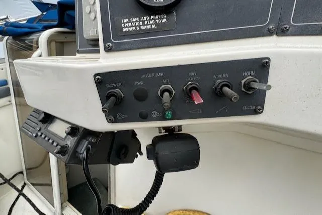 Slide: The Image of Control panel of a 1993 Carver 280 Express boat with various switches and a radio. - 13