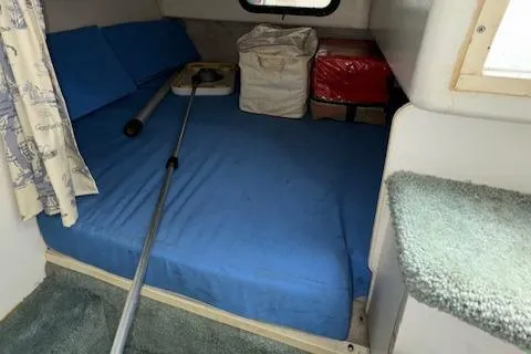 Slide: The Image of Interior cabin of a 1993 Carver 280 Express boat with blue bedding and storage items. - 24