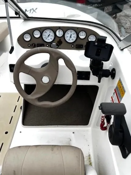 Slide: The Image of 2005 Glastron MX boat dashboard with steering wheel and instrument panel. - 2