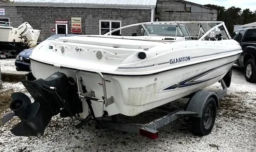 Slide: The Image of 2005 Glastron MX boat on trailer, white exterior, parked outdoors. - 3