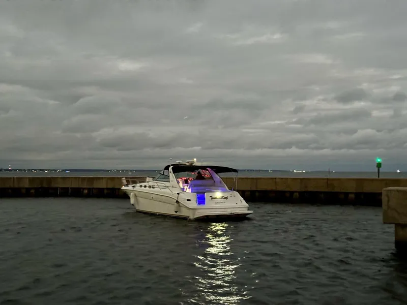 The Image of 1997 Sea Ray 370 Sundancer yacht illuminated at dusk in a harbor setting. - 0