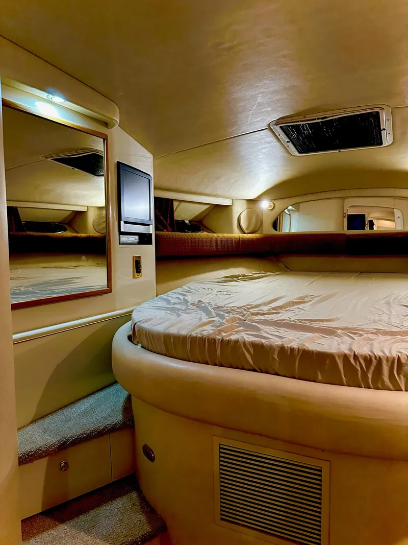 Slide: The Image of 1997 Sea Ray 370 Sundancer cabin interior with bed, mirror, and TV. - 17
