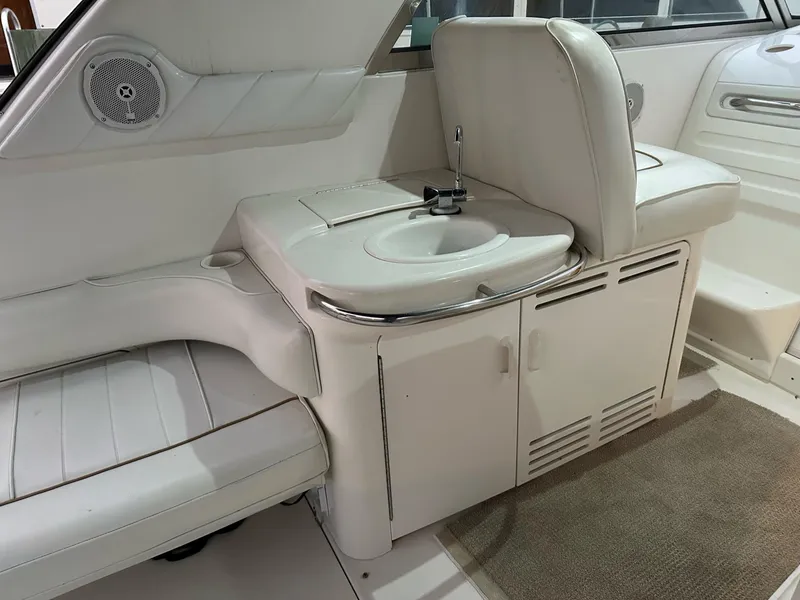 Slide: The Image of Interior of a 1997 Sea Ray 370 Sundancer with white seating and a compact sink. - 23