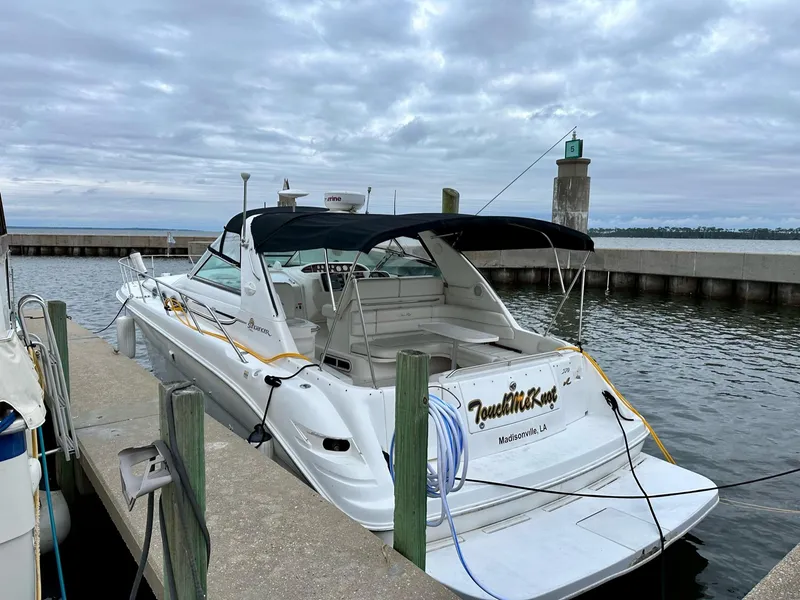 Slide: The Image of 1997 Sea Ray 370 Sundancer docked at a marina under cloudy skies. - 3