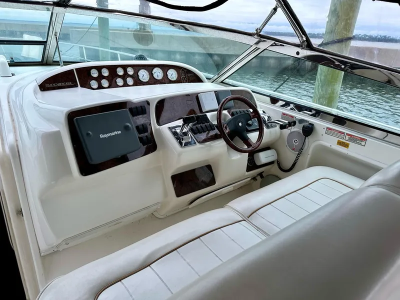 Slide: The Image of 1997 Sea Ray 370 Sundancer helm with Raymarine electronics, featuring a sleek dashboard and comfortable seating. - 4