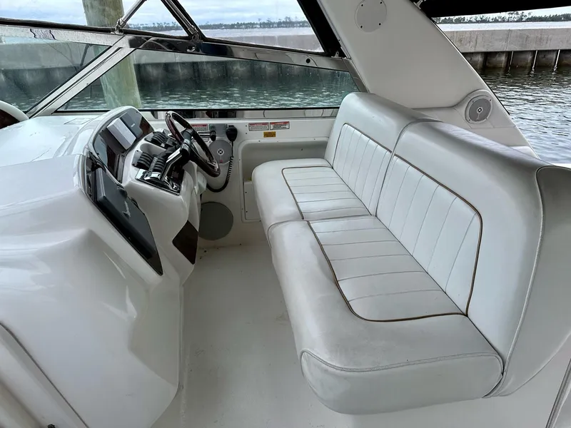Slide: The Image of 1997 Sea Ray 370 Sundancer cockpit with white seating and steering console. - 5