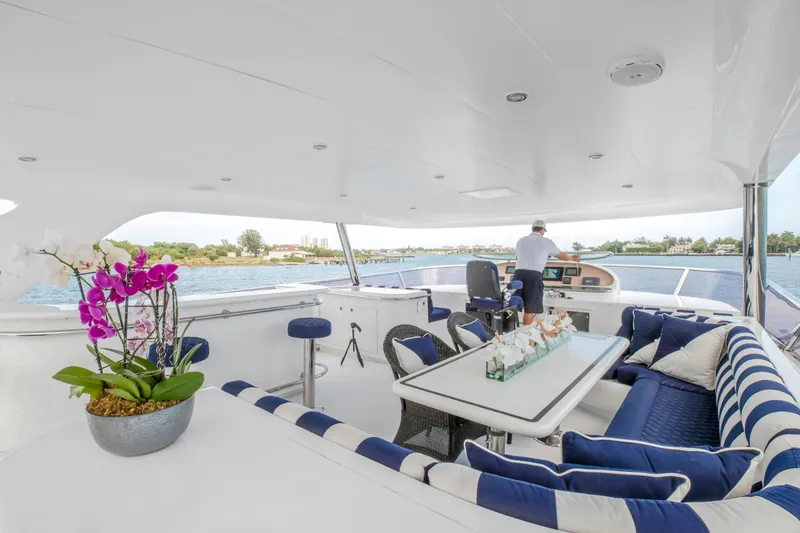 Slide: The Image of Luxurious deck of 2005 Horizon 94 Motoryacht with seating, table, and scenic water view. - 10